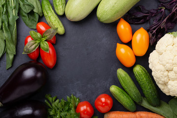 Assorted raw organic vegetables on dark stone background Harvest time Vegetarian eating and dieting concept Top view Copy space