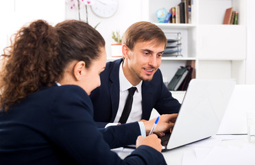 Obraz premium Business male assistant wearing formalwear using laptop