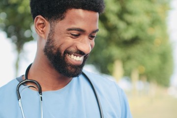 Beautiful happy doctor outside in the park