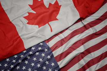 waving colorful flag of united states of america and national flag of canada. © luzitanija