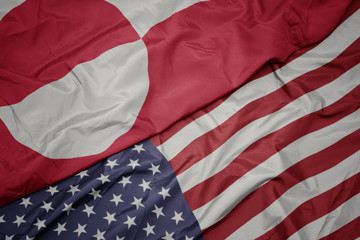 waving colorful flag of united states of america and national flag of greenland. © luzitanija
