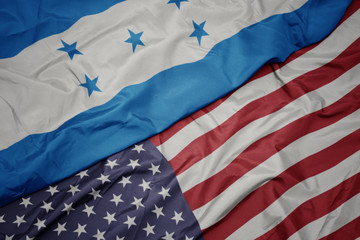 waving colorful flag of united states of america and national flag of honduras.