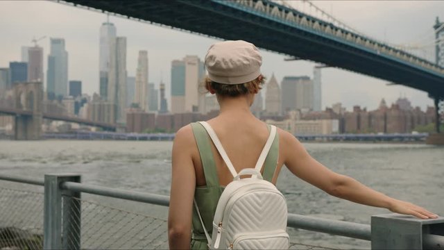 French tourist walks near Manhattan Bridge and enjoying it, walking around Manhattan, first time in New York, moment from trip.