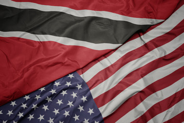 waving colorful flag of united states of america and national flag of trinidad and tobago.