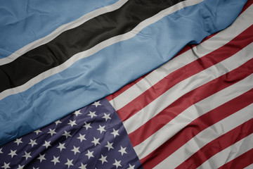 waving colorful flag of united states of america and national flag of botswana.