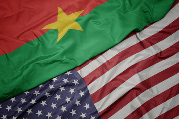 waving colorful flag of united states of america and national flag of burkina faso.