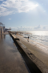 The beach and the embankment of the city of Primorsko-Akhtarsk are flooded with sea water after a summer storm on the Sea of Azov and the sun's rays. Krasnodar Territory, Russia.