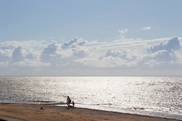 The beach is flooded with sea water after a summer storm at sea and the sun's rays.