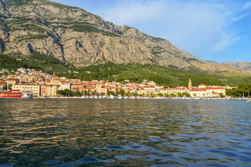 Fototapeta na wymiar Panoramic view of Makarska city center from the sea in Makarska, Croatia on June 17, 2019.