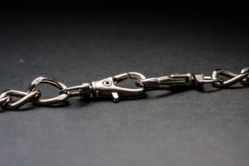 Fototapeta premium Chromed silver chains on a black background. Long and careful. Jewelry.