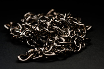 Chromed silver chains on a black background. Long and careful. Jewelry.