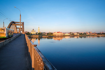 Fototapeta premium Rybinsk, Russia - June, 10, 2019: landscape with the image of Volga embankment in Rybinsk, Russia at sunrise. View from the bridge over Volga