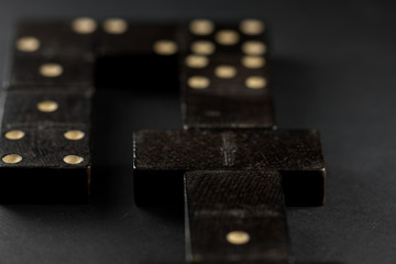 Domino effect, black domino tiles, on a black background. Game of the domino.