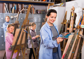 Students working patiently during painting class at art studio