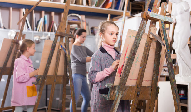 schoolgirls diligently training their painting skills during class at art studio