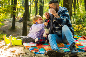 Education upbringing and development. Kid boy play doctor with dad nature background. Games on fresh air. Doctor child in glasses with stethoscope examine patient. Boy in doctor uniform treat patient