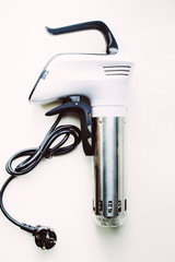 Sous vide stick or rooner close up, top view of a modern utensil for the sous vide cooking technique, ooner,  precision immersion circulator. Isolated on clean background. 