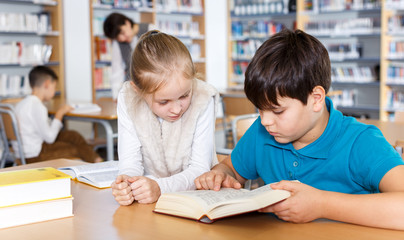 Fototapeta na wymiar Girl and boy studying in school library
