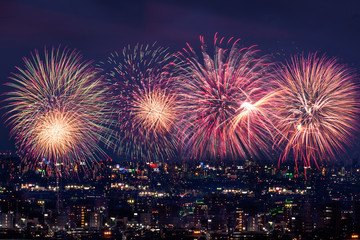 夜の町並みに打ち上がる花火のイメージ