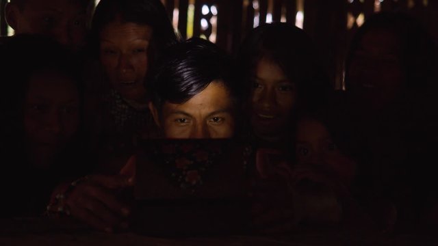 Amazonian Indigenous Group Of Friends Astonished To Open A Light Box In The Dark In Ecuador