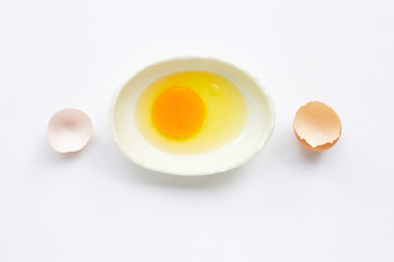 Egg yolk and white in a bowl on white background.