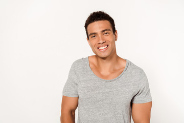 Obraz premium happy mixed race man smiling while looking at camera on white