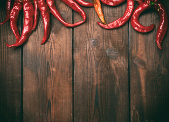 ripe red chili peppers on a brown wooden vintage background