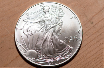 Silver Eagle Coins and other money with wood and wicker background