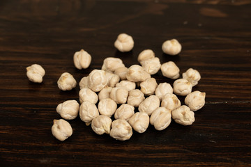 Raw chickpeas  on a dark wooden background. top view, out of range.