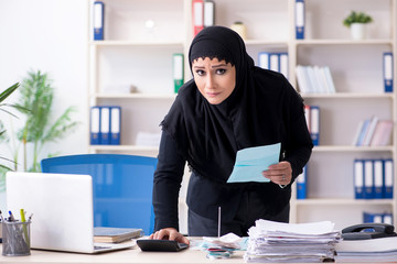 Female employee bookkeeper in hijab working in the office