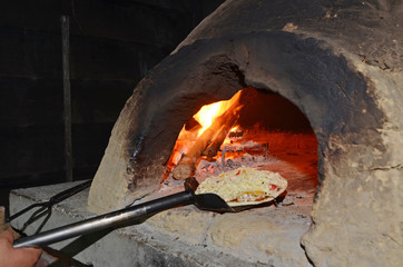 Pizza on  spatula ready to go into oven   