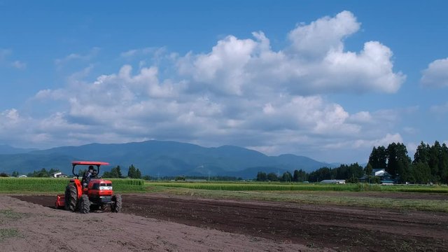 空撮,トラクターで農地を耕す日本人の男性,農業イメージ