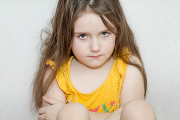 a portrait of emotional upset pensive and meditative little girl on a white background
