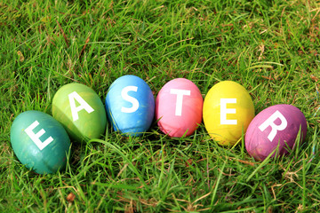 Many Easter eggs have many colors placed on green grass.