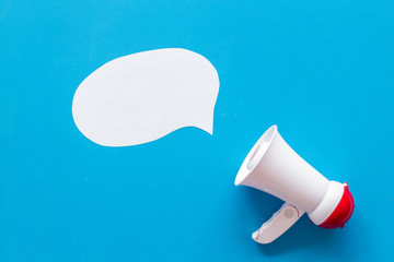 Megaphone with bubble for announcement text on blue background top view space for text