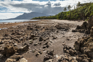 rocky beach near Plum on New Caledonia coast with Mont Dore mountain in background