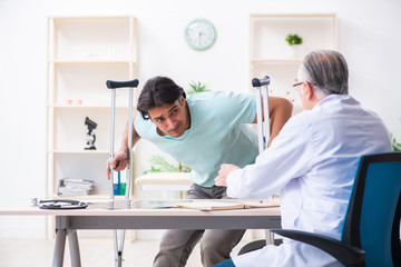 Obraz premium Young leg injured male patient visiting old doctor