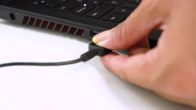 USB flash drive connected to a Laptop. Hand disconnecting Usb flash drive cable to computer. Plug / unplug flash drive to netbook. 4K (UHD)