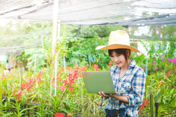 Women farmers Flower garden export abroad Standing holding a laptop Send information to customers for trading