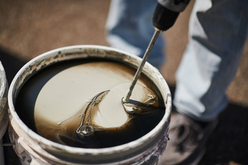 Bucket with mixing paint for wall, diy concept.
