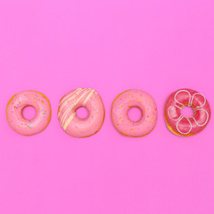 Donuts on a pink background. Flat lay fast food art