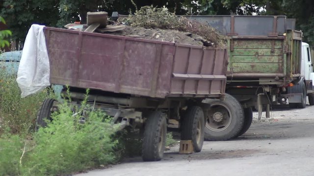  flatbed trailer with garbage on a town street   