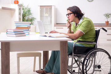 Young male student in wheelchair at home