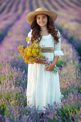 Girl in nature. Little girl in a field with flowers. Lavender, right. 