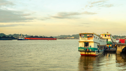 Fototapeta na wymiar the traffic at Mahakam river, Samarinda, Borneo, Indonesia. tugboat with barge of coal and wooden passenger which take passenger to the upper Mahakam