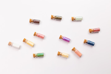 Cosmetics, makeup and beauty concept - Colourful eye shadow in small glass boxes on white background, top view close up.