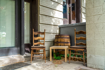 Fototapeta na wymiar Concrete porch of a home with wooden chairs square table and barrel