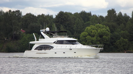 Fototapeta na wymiar Big white beautiful luxury motor yacht floating on river on summer day, motorboat cruise