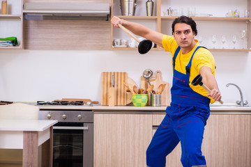 Young male contractor repairing tap at home