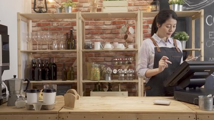 fast motion female barista working in cafe counter. waitress make drink for client on coffee machine after checking customer order on tablet. worker put croissant and beverage on tray and walk out